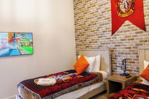 A bedroom with a brick wall, a bed with a red and black patterned blanket, an orange pillow, and a headboard. - Entire Beautiful 5-bedroom Rental Minutes From Disney!  -No Pets Allowed- (Davenport)