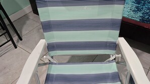 A striped hospital bed with a headrest and footrest, positioned on a tiled floor. - Centrally located 1 bedroom efficiency (georgetown)