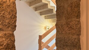 A stone staircase with a wooden handrail leading to a light fixture. - Hôtel confidentiel Le Grécale **** (Pianotolli-Caldarello)