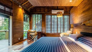 Un dormitorio tipo cabaña de madera con una cama grande, un escritorio y una silla.
