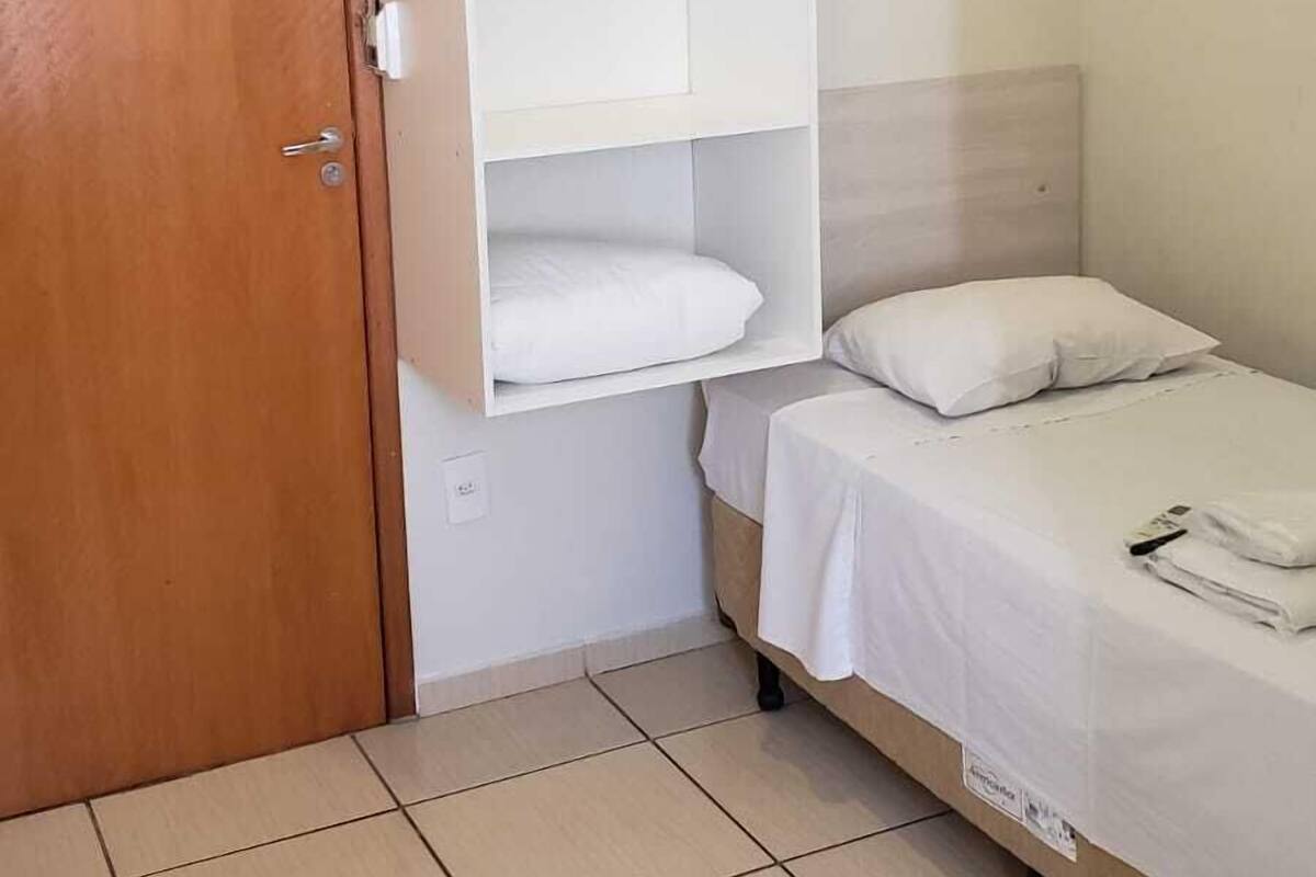 Une chambre à coucher comprenant un lit, une armoire et une étagère.