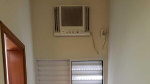 A small room with a window, a chair, and a radiator. - Hotel Viracopos de Indaiatuba Ltda EPP (Indaiatuba)