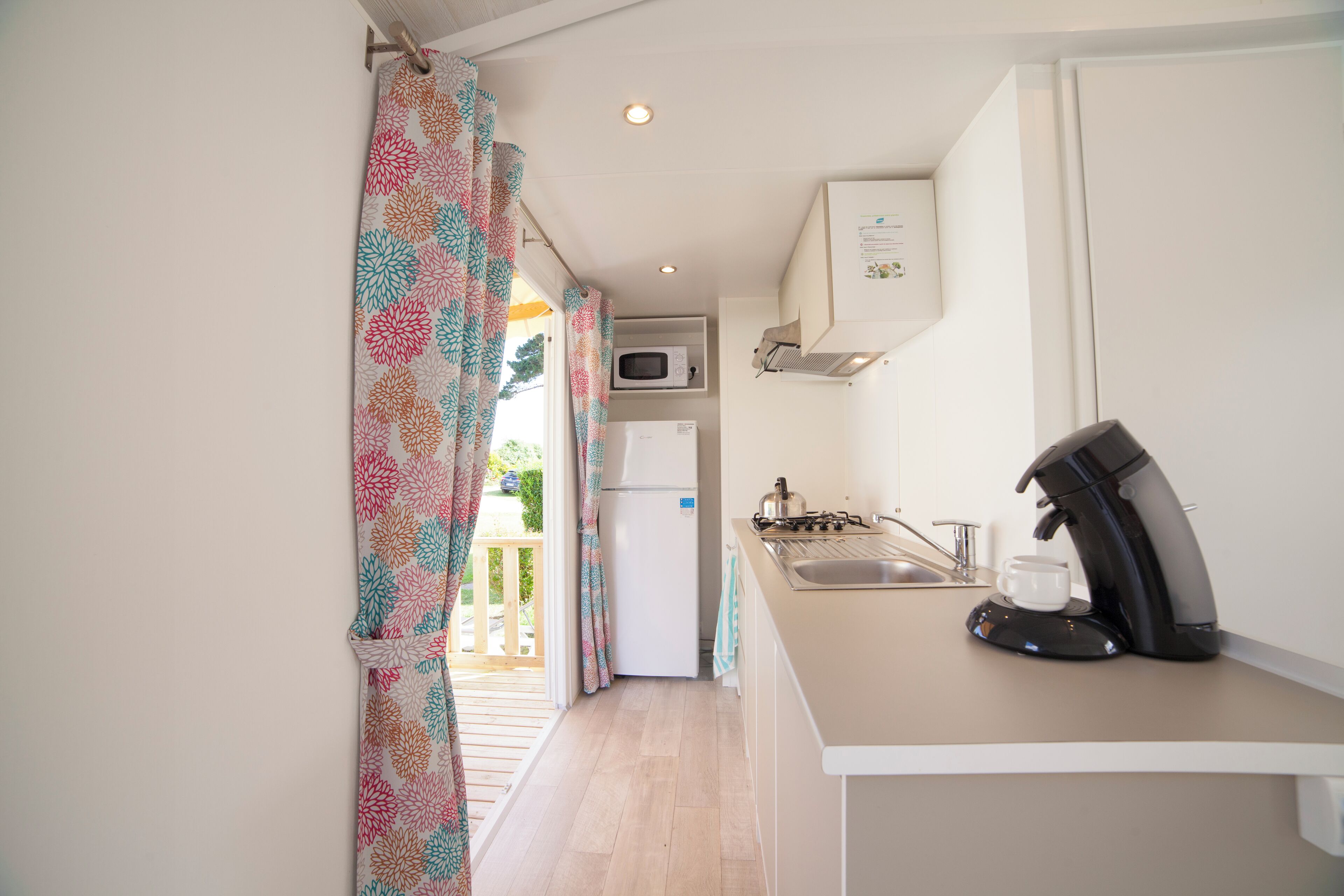 A compact kitchen with a microwave, refrigerator, and coffee maker.