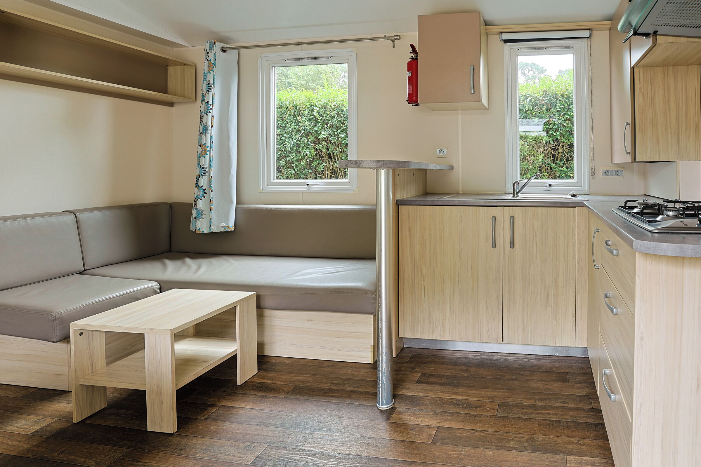 Una kitchenette compacta con estufa, lavamanos y armarios de madera.