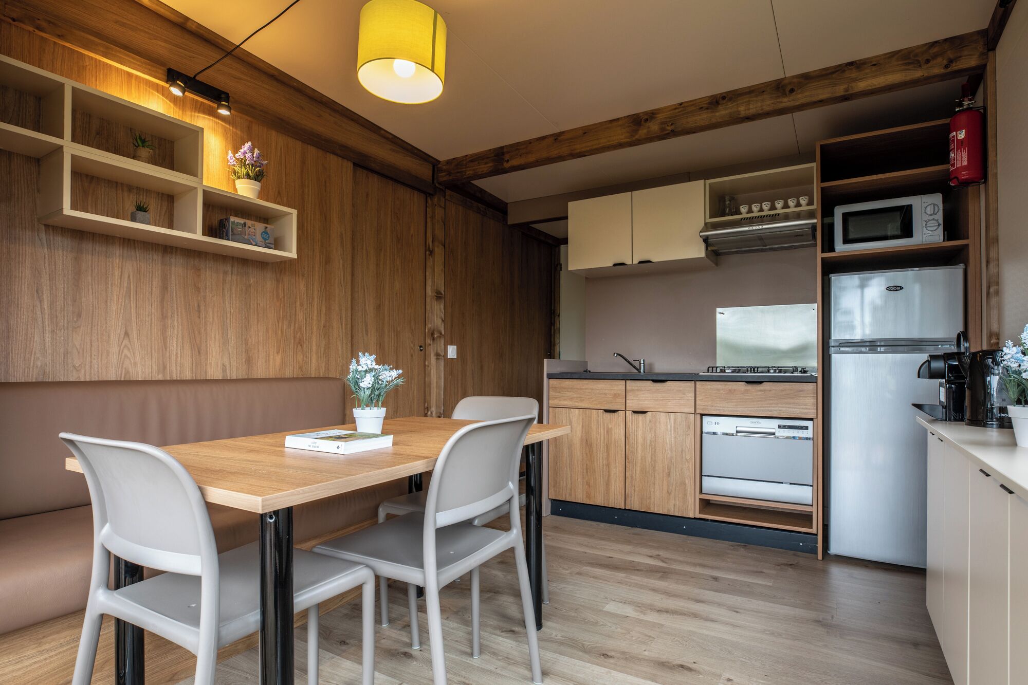 A modern kitchen with wooden cabinets, a built-in oven, and a stainless steel refrigerator.
