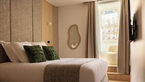 A neatly made bed with pillows, a mirror on the wall, and a window with curtains. - Cosy Apat With AC -3br- 8P- Canal Saint-martin (Paris)