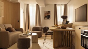 A modern living room with a sofa, ottoman, and a dining area with a table and chairs. - Cosy Apat With AC -3br- 8P- Canal Saint-martin (Paris)