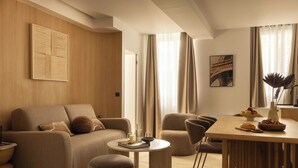 A modern living room with a sofa, armchairs, a coffee table, and a dining area with a table and chairs. - Cosy Apat With AC -3br- 8P- Canal Saint-martin (Paris)