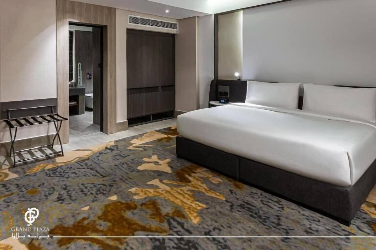 Een moderne hotelkamer met een groot bed, een bureau en een inloopkast.