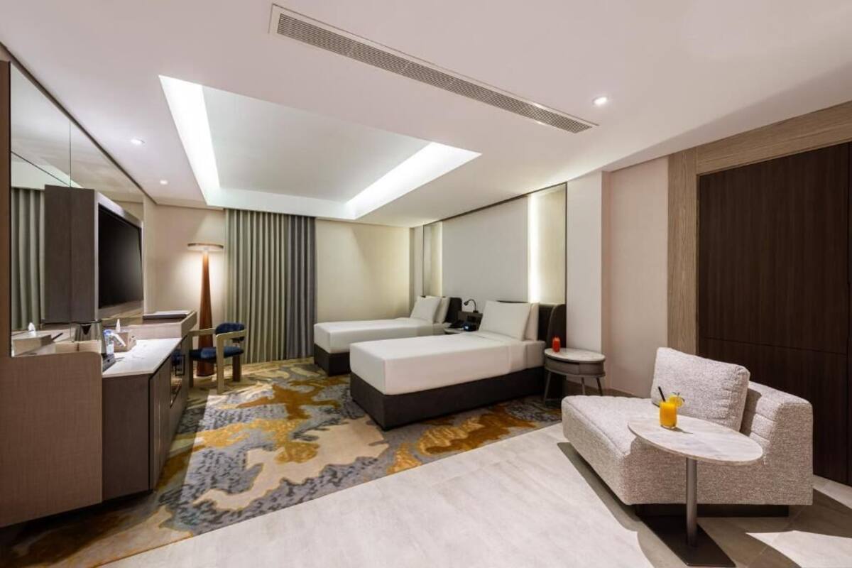 Een hotelkamer met een bed, een bureau, een stoel, een kleine tafel en een bank.