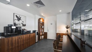 Una cocina moderna con encimera de madera, cafetera y un cuadro con una foto de un perro.