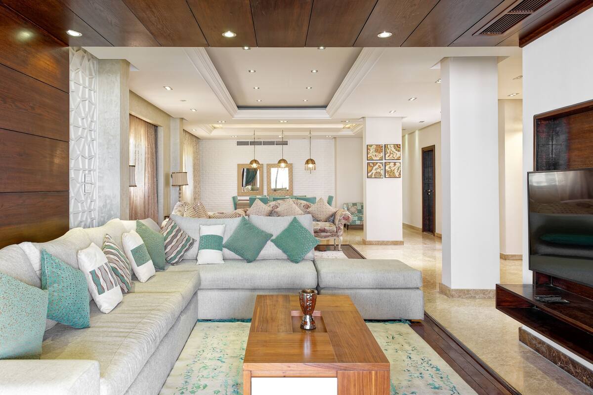 A modern living room with a sectional sofa, a coffee table, and a flat-screen TV.