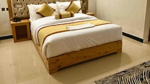 Ein Schlafzimmer mit einem Holzbett, weißer Bettwäsche und einem dekorativen Kopfteil.
