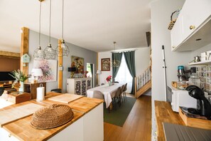 A kitchen with wooden countertops, a dining area with a table and chairs, and a staircase leading to another level.