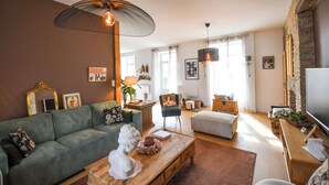 A living room with a green sofa, a wooden coffee table, and a stone fireplace.