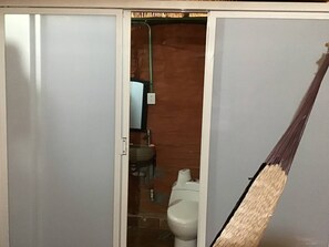 A bathroom with a toilet, sink, and mirror.