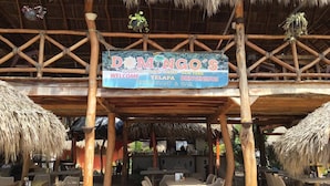 A restaurant named 'DOMINGO'S' with a signboard indicating it is a restaurant and bar.