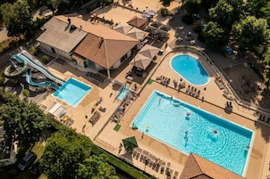 Una piscina al aire libre de temporada, sombrillas, tumbonas