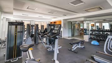 A gym with various exercise equipment, including treadmills, weight machines, and free weights.