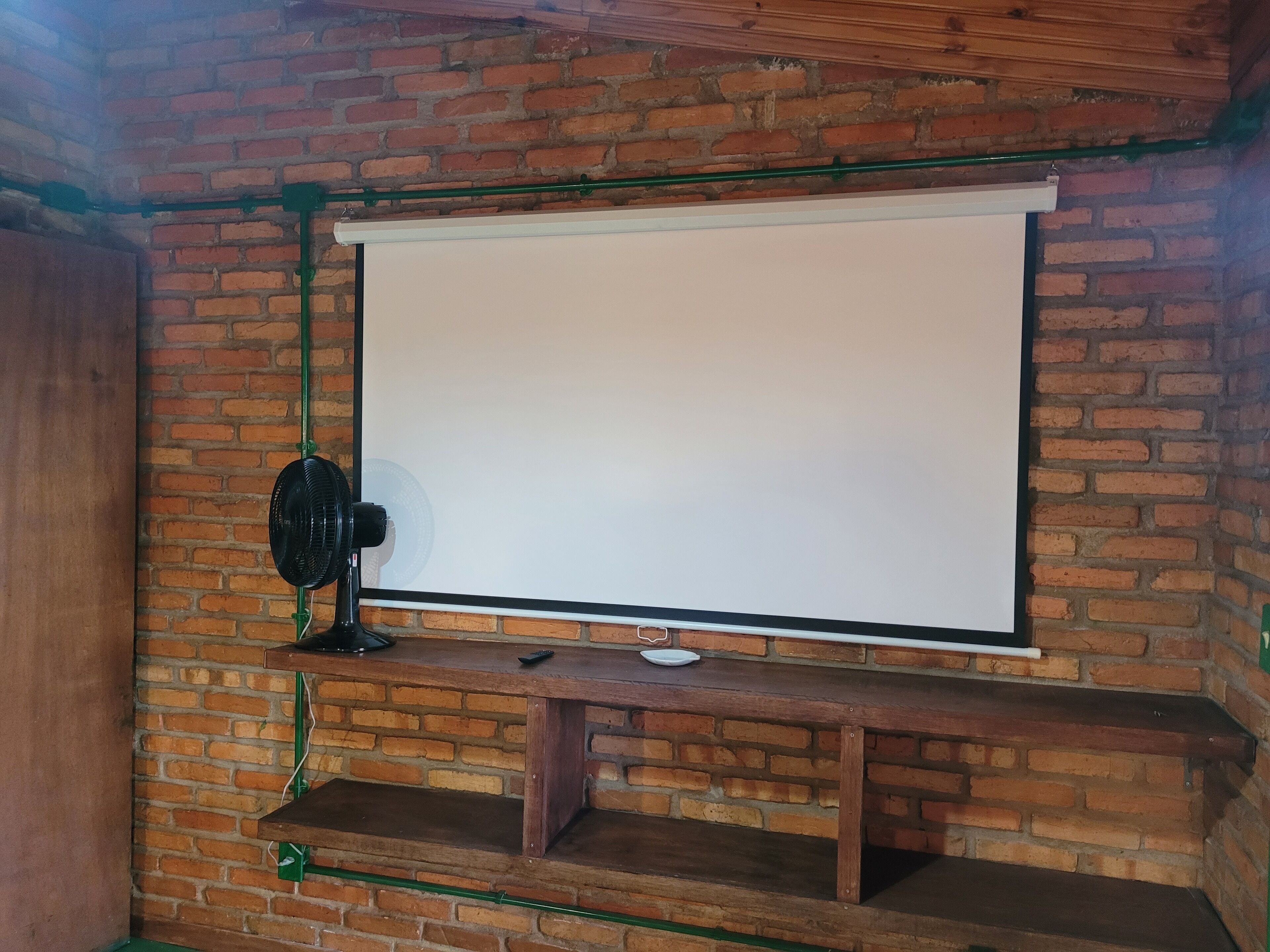 Un muro de ladrillo con una pantalla blanca proyectada.
