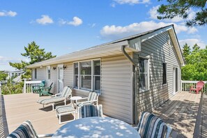 A single-story house with a covered porch, several chairs, and a table. - Charming Oceanside Getaway! (South Bethany)