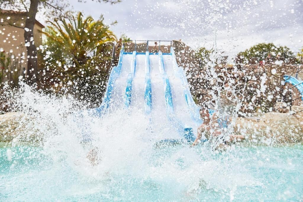 En vandrutsjebane med flere baner, omgivet af en pool og palmer.