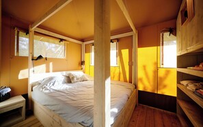 A room with a bed, a small table, and a shelf with items. - RCN Domaine de la Noguière (Le Muy)