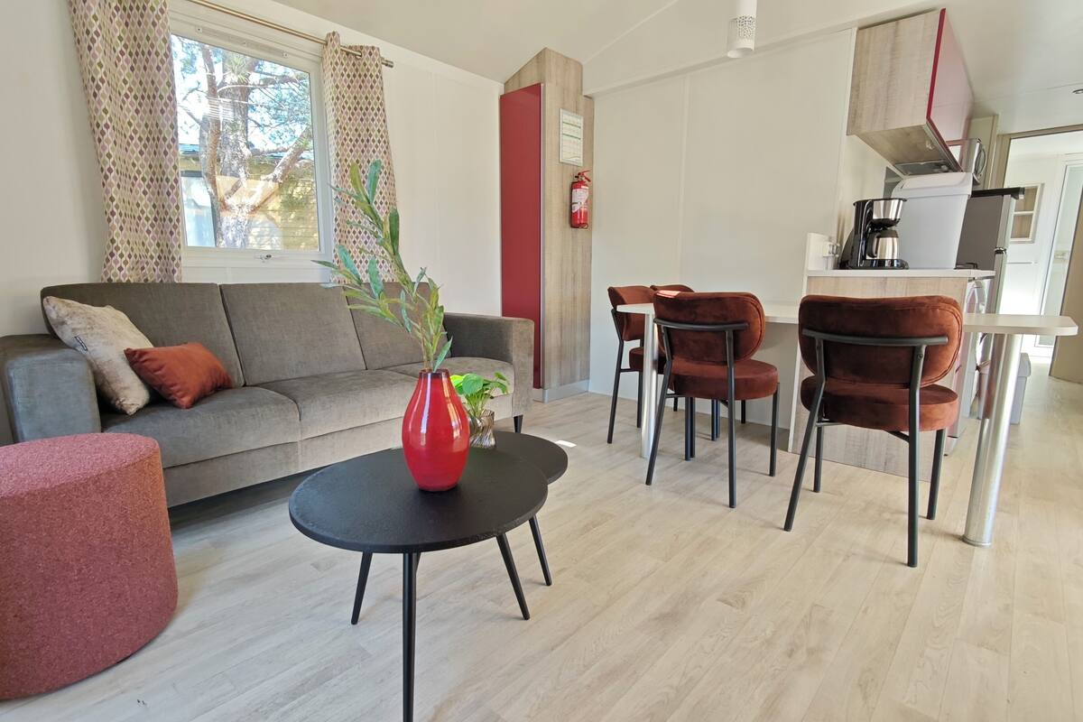 Una sala de estar moderna con un sofá, una mesa redonda y dos sillones.