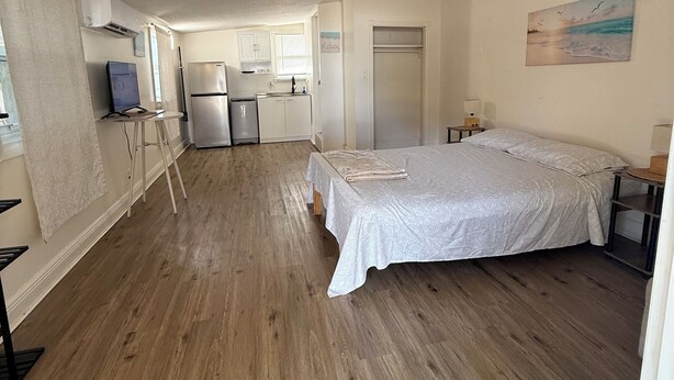 Una habitación amplia con una cama grande, un kitchenette y vistas al océano.