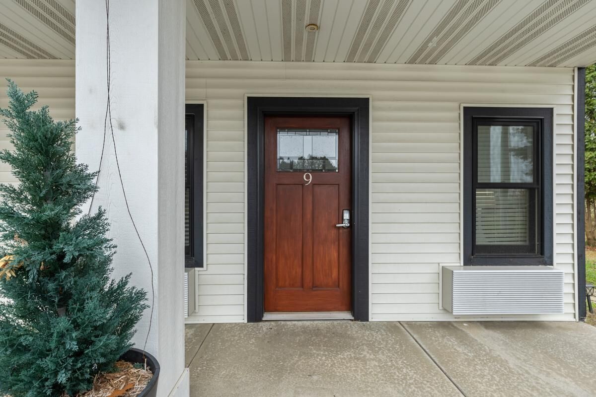 A house with a wooden front door, number 9, and a window to the right.