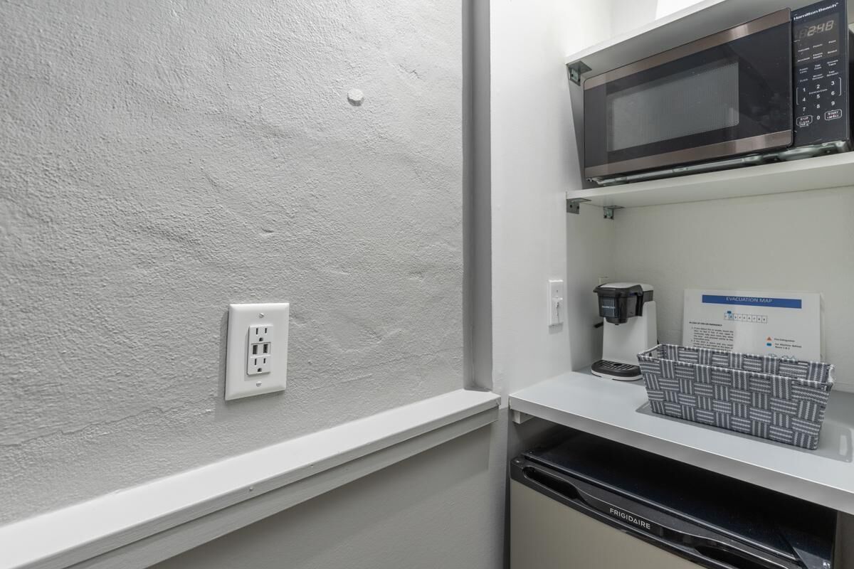 A kitchenette with a microwave, coffee maker, and a Frigidaire dishwasher.