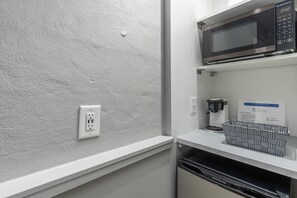 Una kitchenette con microondas, cafetera y lavavajillas Frigidaire.