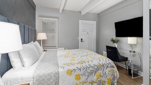 Un dormitorio moderno con cama, lámparas de noche, escritorio y silla.