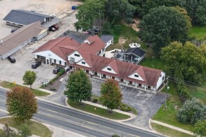 A motel with multiple units, a parking lot, and a road in the foreground. - Blue Star #8 Location, Location 12 person hot tub! (Douglas)