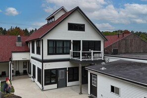 A two-story house with a balcony, large windows, and a red roof. - Blue Star Penthouse Location 12 person hot tub (Douglas)