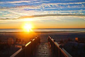 A wooden boardwalk leading to a beach with a sunset in the background. - Ocean Front 3rd Floor Villa in Palmetto Dunes! (Hilton Head Island)