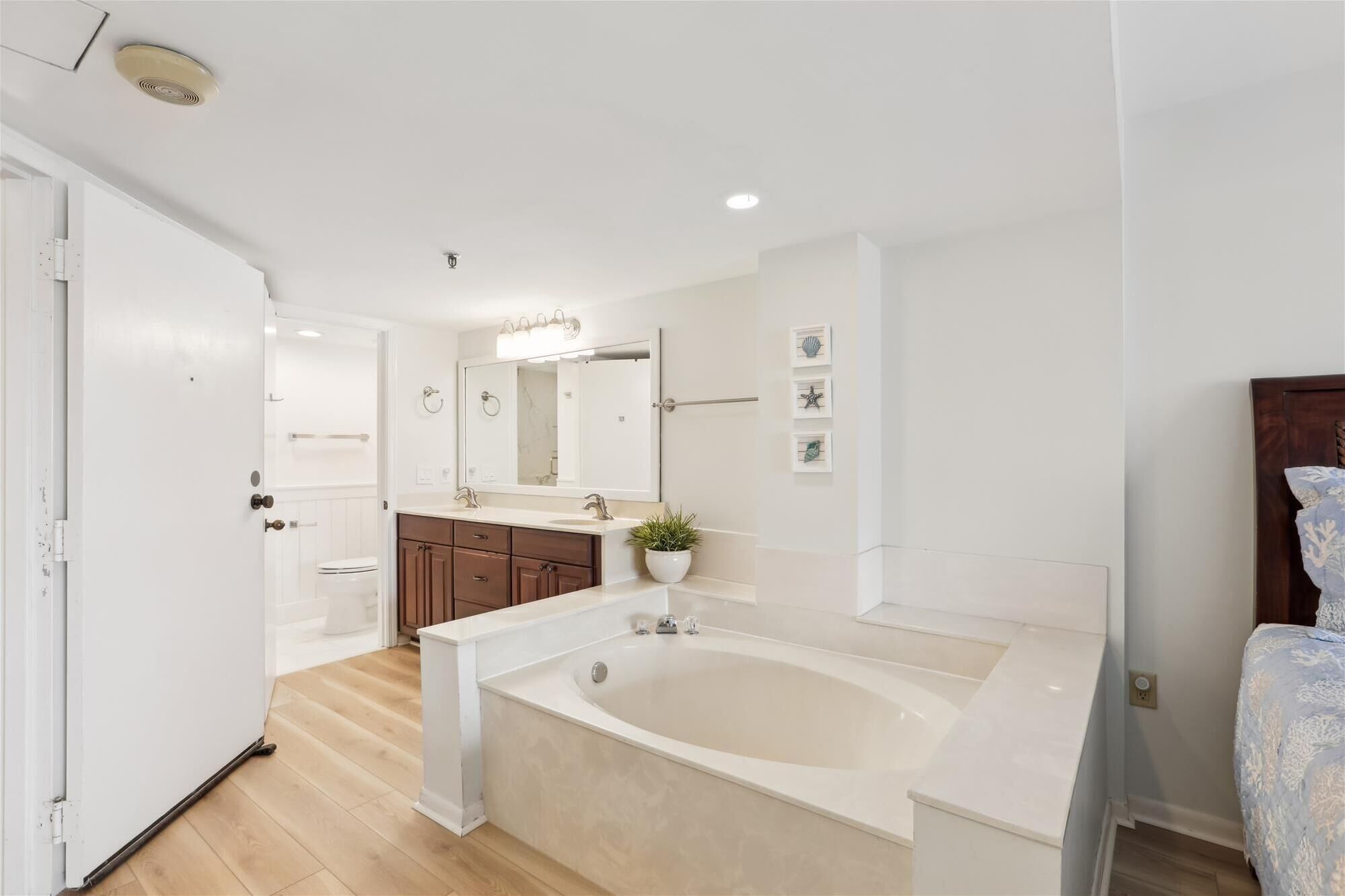 A modern bathroom with a freestanding bathtub, a vanity with a mirror, and a toilet.