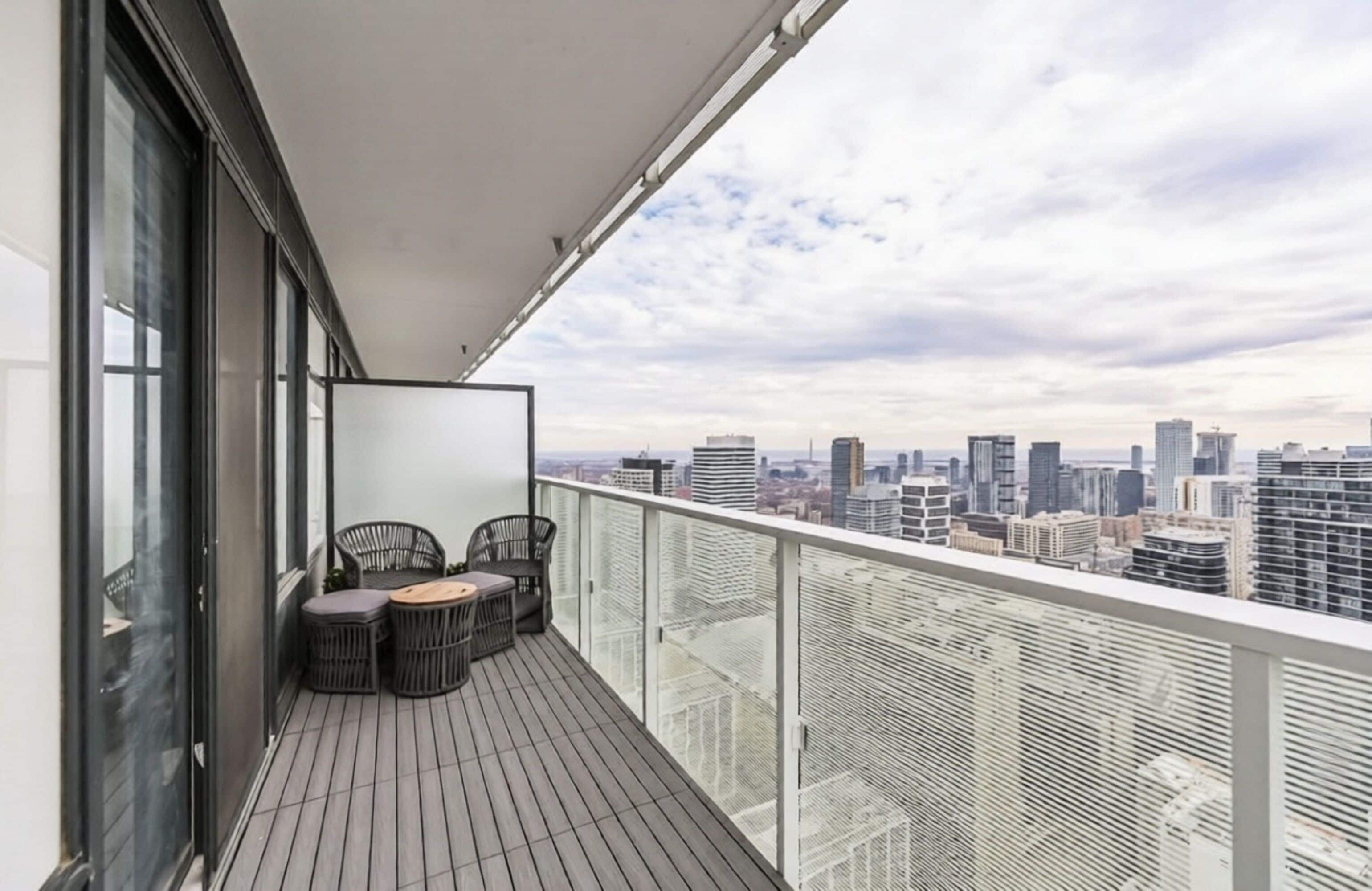 Un balcón con vista a la ciudad, con una mesa y sillas.