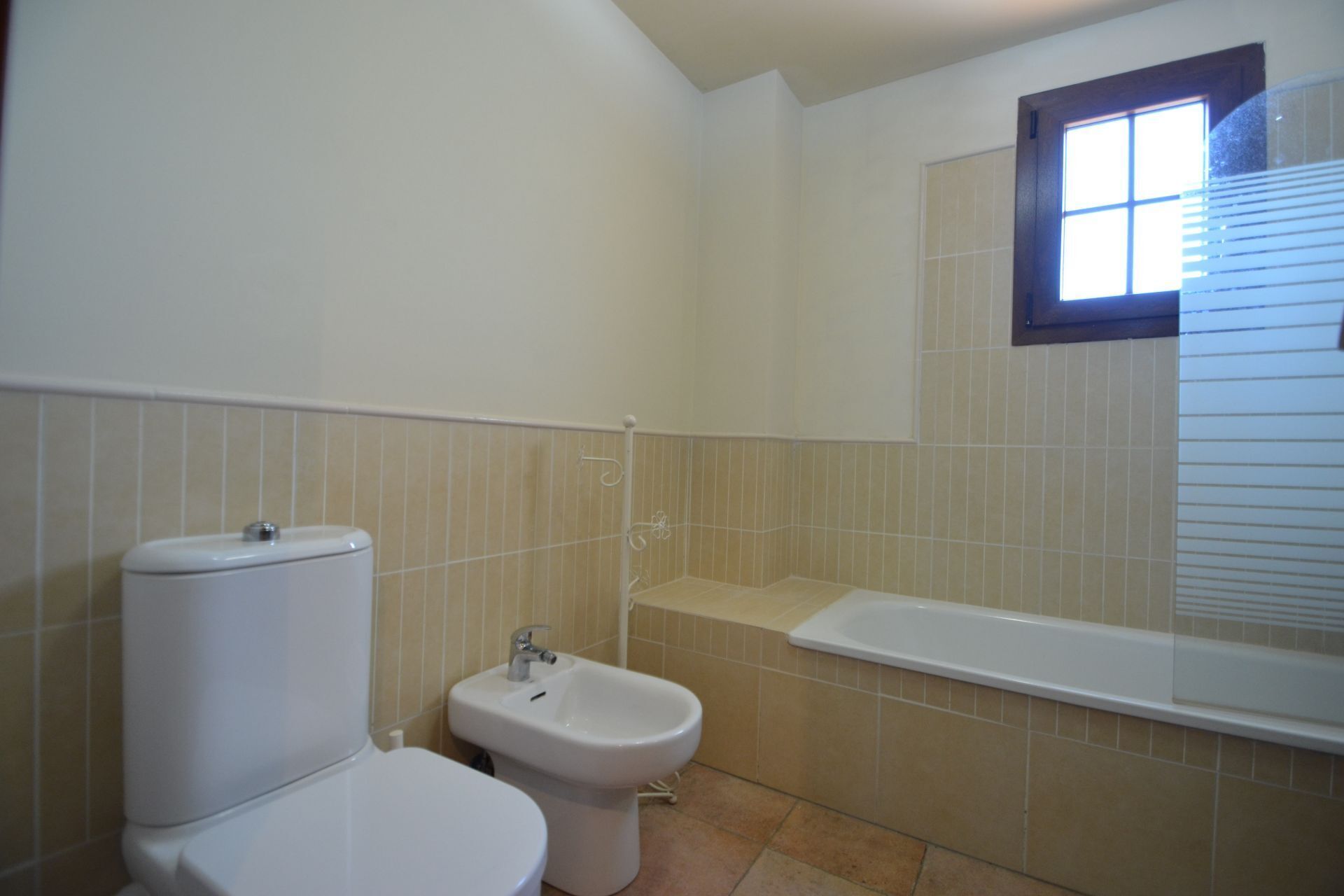 Un baño con inodoro, bidé y bañera.