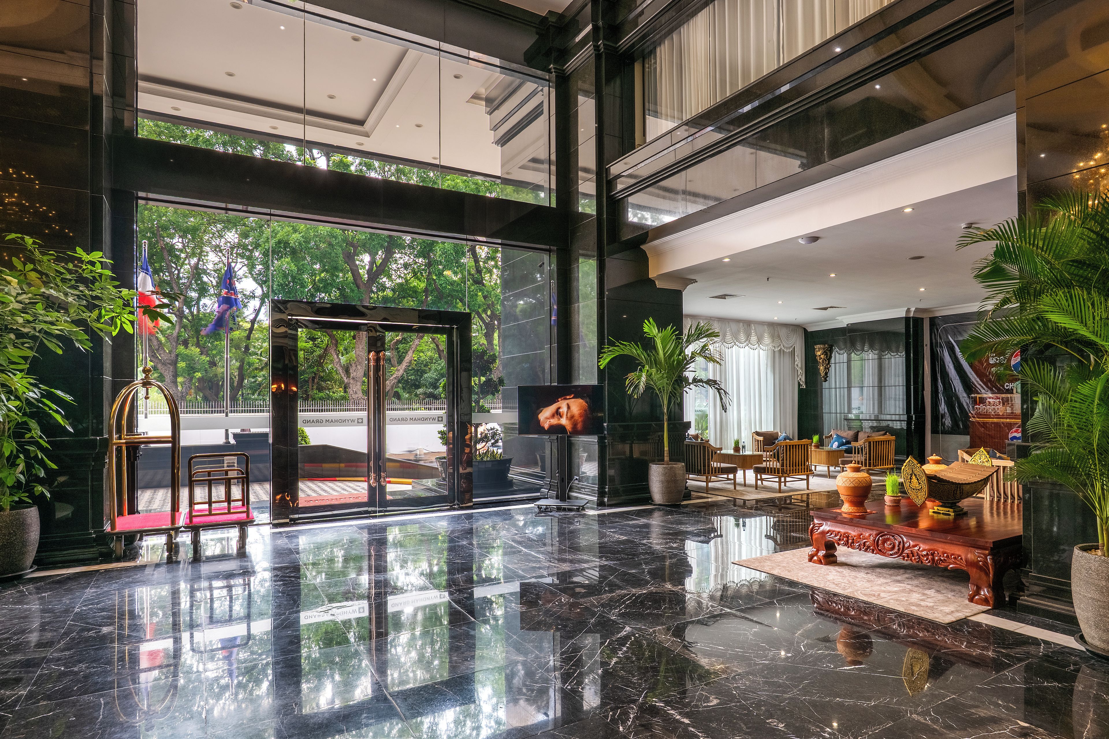 A lobby with a marble floor, a reception desk, and a seating area with chairs and tables.