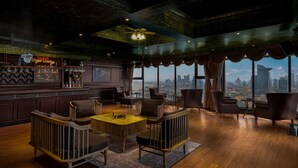 Uma área de bar com vista para a cidade, piso de madeira e móveis modernos.