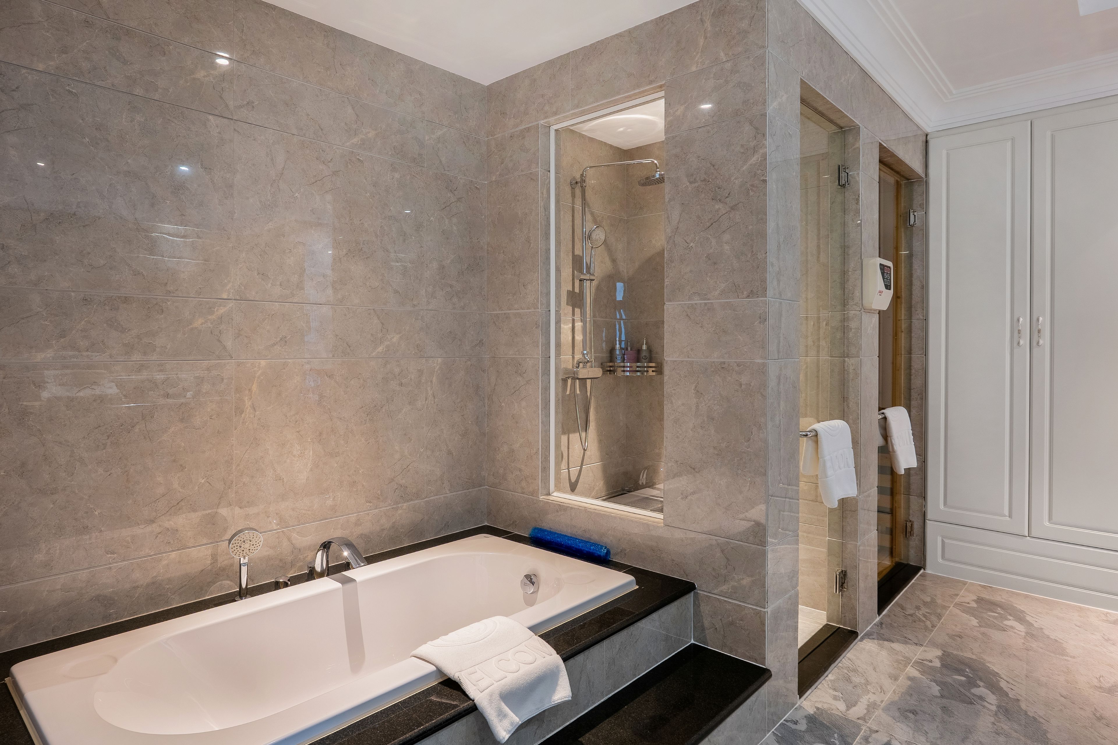 A modern bathroom with a bathtub, a shower, and a vanity.