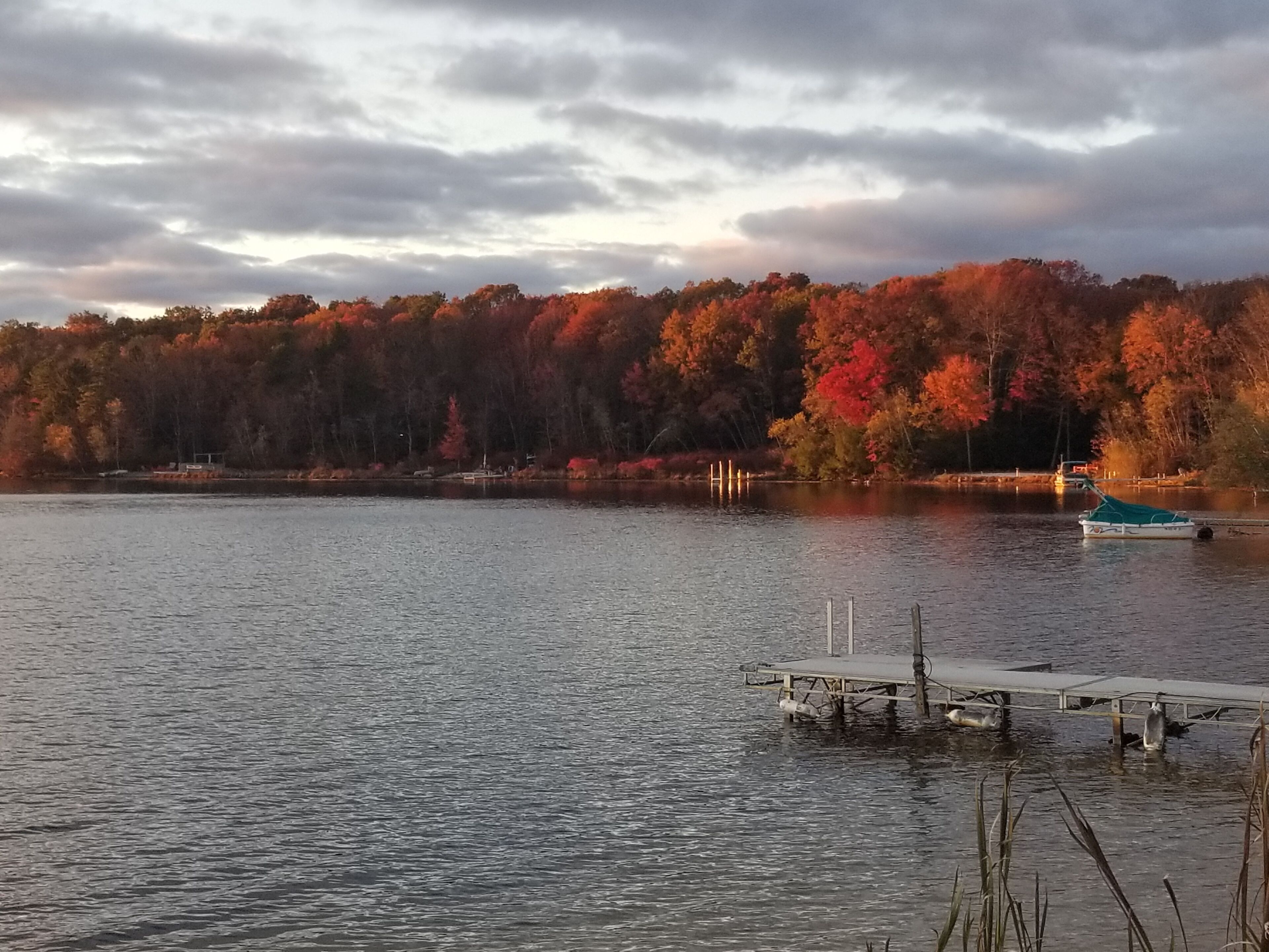 A lake with a dock and a boat.