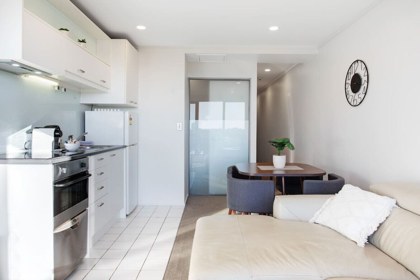 A modern apartment with a kitchen, dining area, and living room.