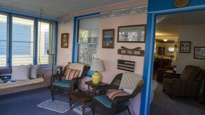 A cozy living room with wicker furniture, a swing seat, and a dining area. - 314 E. 3rd in Lakeside (Lakeside)