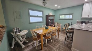 A dining area with a wooden table and chairs, a cabinet, and a kitchen counter with appliances. - 314 E. 3rd in Lakeside (Lakeside)