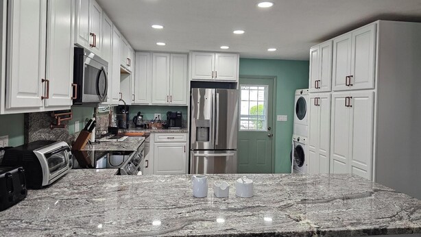 A modern kitchen with white cabinets, stainless steel appliances, and a granite countertop. - 314 E. 3rd in Lakeside (Lakeside)