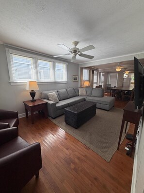 A living room with a sectional sofa, a coffee table, a TV, and a ceiling fan. - 344 Maple in Lakeside (Lakeside)