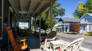 A porch with wicker furniture, a flag, and a view of the street. - 344 Maple in Lakeside (Lakeside)