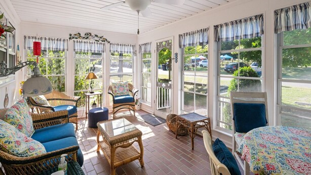A sunlit room with wicker furniture, large windows, and a ceiling fan. - 660 Walnut Cottage in Lakeside (Lakeside)
